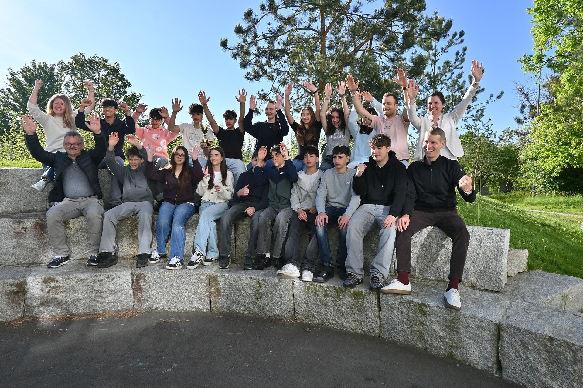 Eine Gruppe Schüler und Lehrpersonen heben in Freude die Hände um ihren Sieg in der Foodwaste Challenge zu feiern